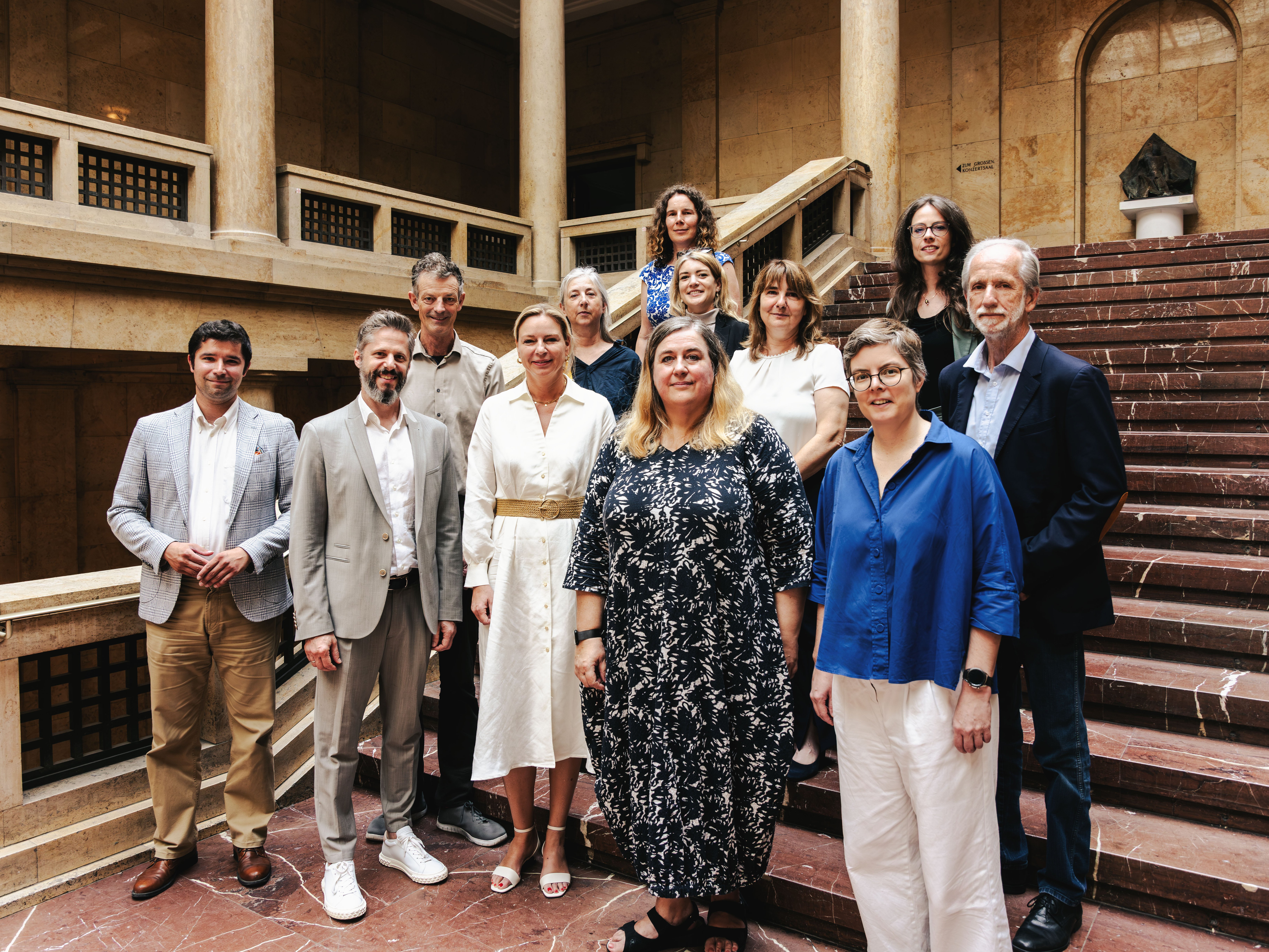 Erste Reihe (v.l.n.r.): Yannick Kunz (HMTM), Prof. Rainer Kotzian (HfMN), Stephanie Jacobs (StMWK), Prof. Karen Pontoppidan (AdbKM), Prof. Lydia Grün (HMTM); zweite Reihe (v.l.n.r.): Daniel Sponsel (HFF), Prof. Eva von Platen-Hallermund (AdBKN), Marina Weber (HfMN), Dr. Susanne Balthasar (HfMWü), Prof. Dr. Christoph Wünsch (HfMWü); dritte Reihe (v.l.n.r): Corinna Deschauer (AdBKM), Gila Sommerrock (HFF)